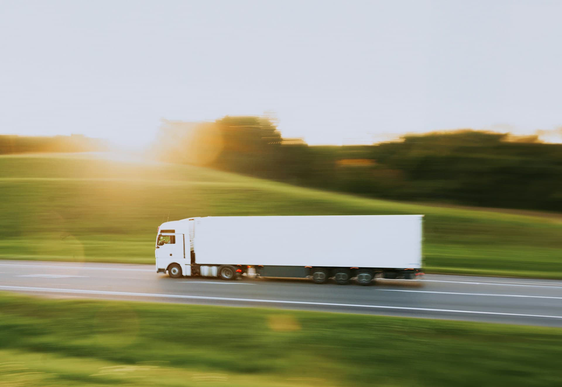 Semi-remorque blanc sur une route rurale